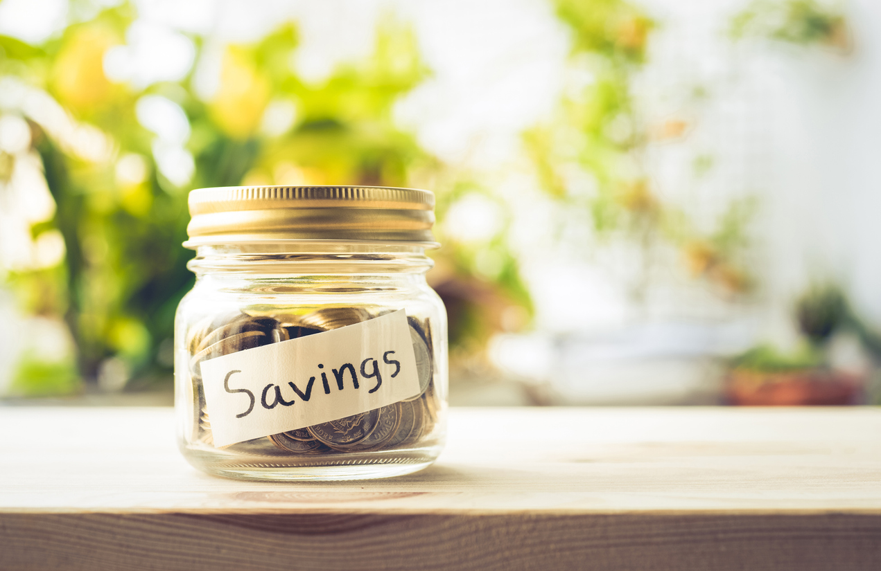 Savings word with money coin in glass jar.For savings and financial investment concept ideas.